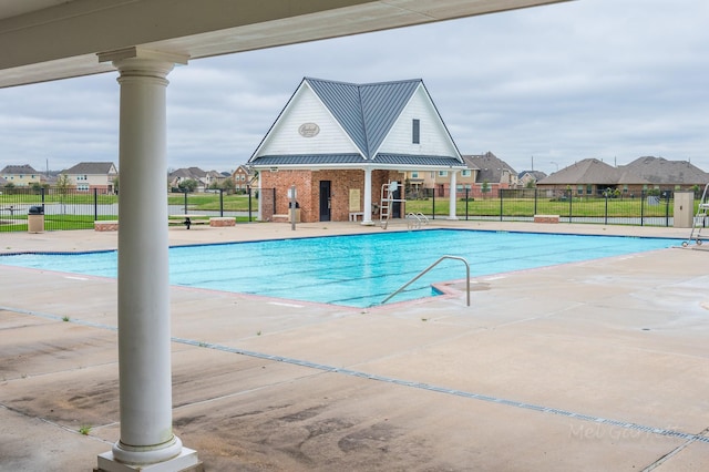 community pool with fence, a residential view, and a patio