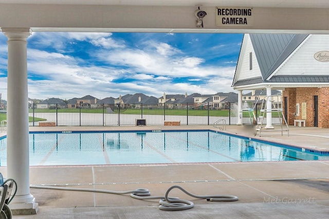community pool featuring a residential view, fence, and a patio area