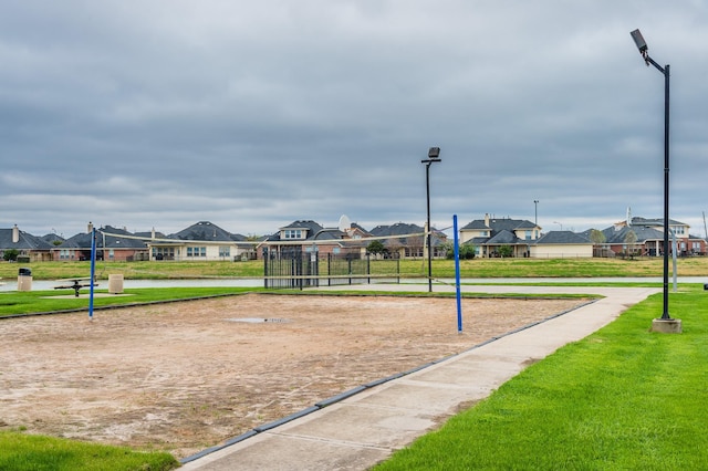 surrounding community with volleyball court, a residential view, and a lawn