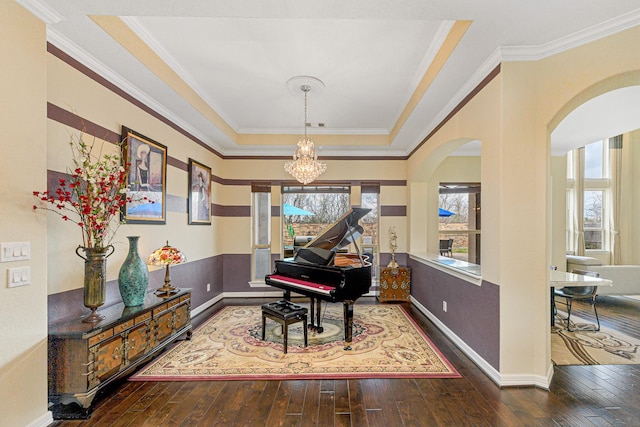 living area featuring hardwood / wood-style flooring, baseboards, a chandelier, and crown molding