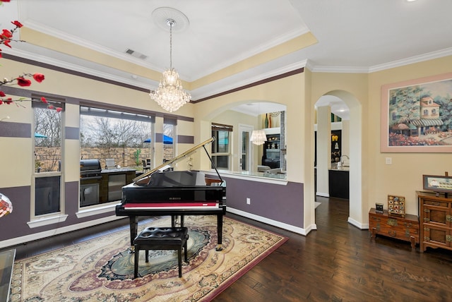 interior space featuring crown molding, a raised ceiling, visible vents, hardwood / wood-style floors, and baseboards