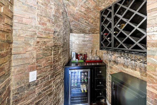 bar featuring a dry bar, brick wall, and wine cooler