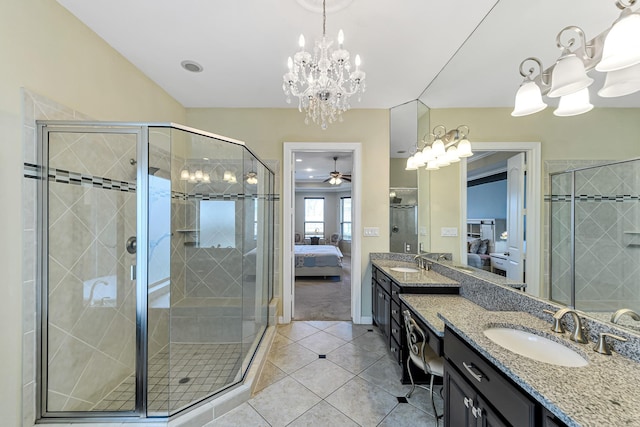 ensuite bathroom featuring connected bathroom, ceiling fan with notable chandelier, vanity, a shower stall, and tile patterned floors