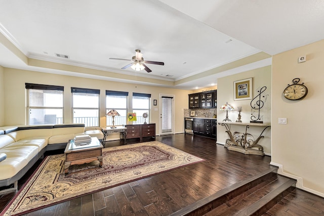 living room with a dry bar, wood-type flooring, a raised ceiling, and visible vents