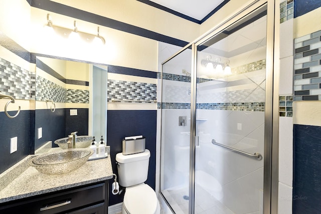 bathroom with toilet, a shower stall, and vanity