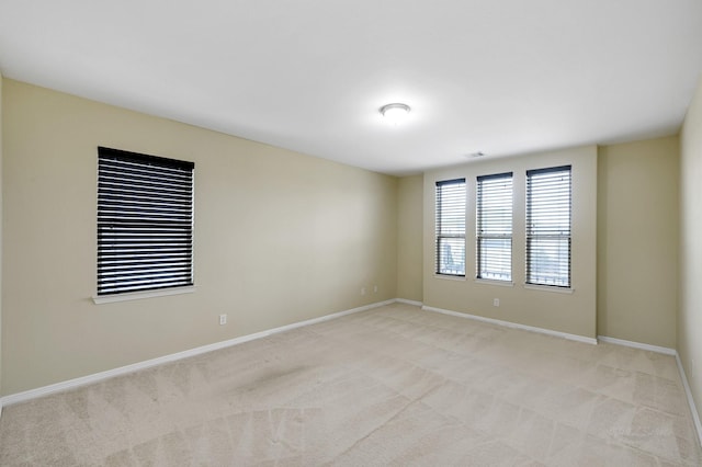 unfurnished room featuring light carpet, visible vents, and baseboards