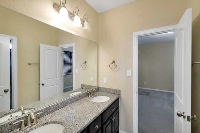 full bathroom with a sink, baseboards, and double vanity