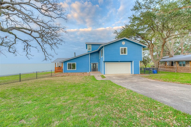 view of front of house featuring a water view, a front yard, and a garage