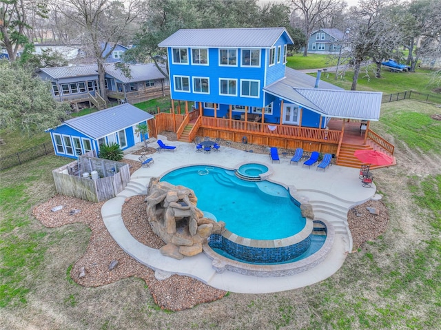 view of pool with a deck, a patio, an in ground hot tub, and a sunroom
