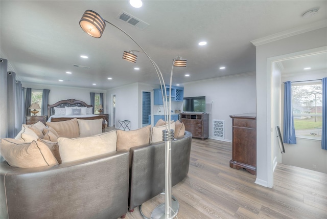 living room featuring ornamental molding and light hardwood / wood-style flooring