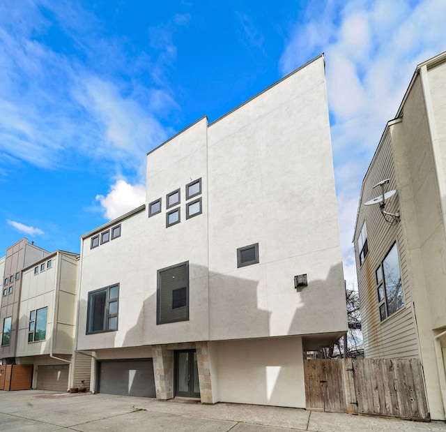 exterior space featuring an attached garage and fence