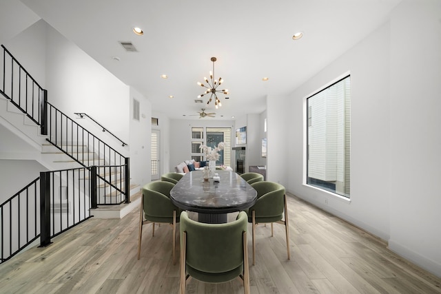 dining room with stairs, light wood-style floors, recessed lighting, and a notable chandelier