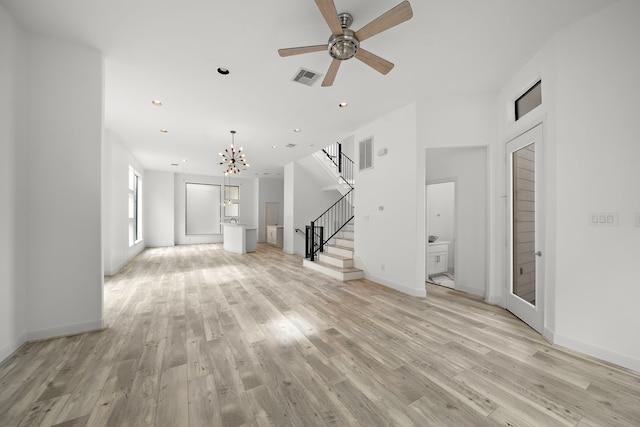 unfurnished living room featuring stairs, light wood finished floors, and visible vents