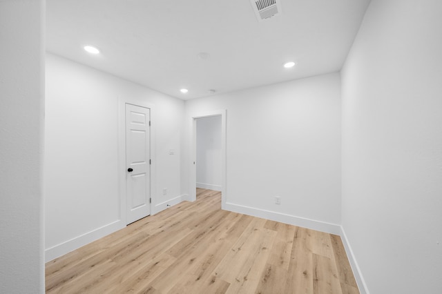 empty room with baseboards, visible vents, wood finished floors, and recessed lighting