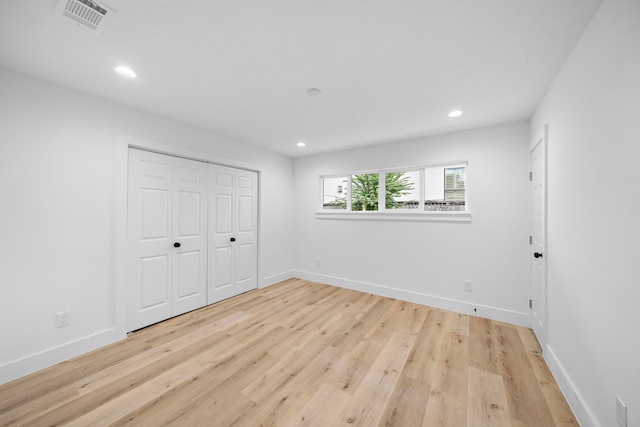 unfurnished bedroom with baseboards, wood finished floors, and recessed lighting