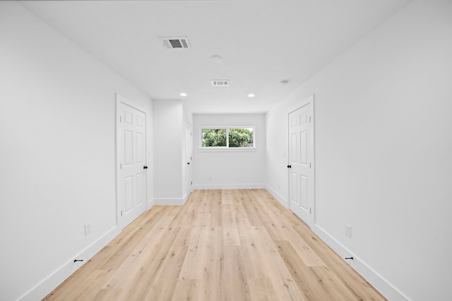 spare room with light wood-style flooring, recessed lighting, visible vents, and baseboards