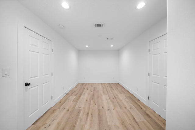 unfurnished room featuring light wood finished floors, baseboards, visible vents, and recessed lighting