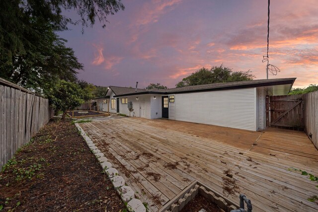 4102 Levonshire Dr, Houston, TX 77025 - back of house at dusk featuring a deck and a fenced backyard
