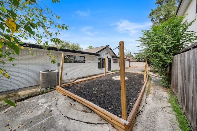 view of yard featuring a patio, central AC unit, and a fenced backyard