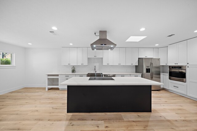4102 Levonshire Dr, Houston, TX 77025 - kitchen with appliances with stainless steel finishes, a sink, island range hood, a kitchen island, and light countertops