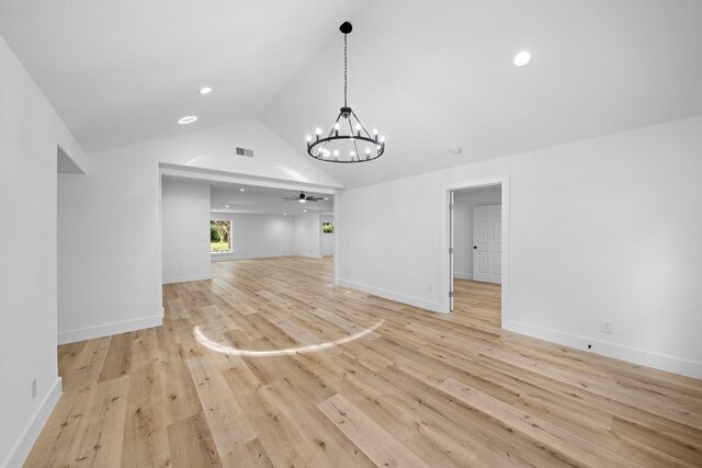 4102 Levonshire Dr, Houston, TX 77025 - unfurnished living room with a chandelier, ceiling fan, vaulted ceiling, light wood-style floors, and baseboards