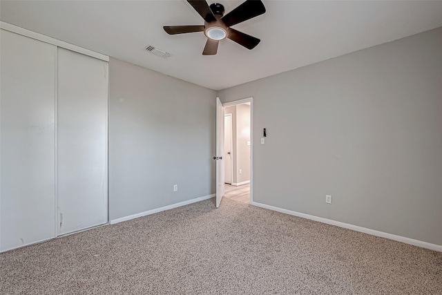 spare room with ceiling fan and light colored carpet