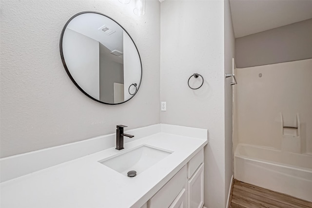 bathroom featuring hardwood / wood-style flooring, vanity, and shower / bath combination