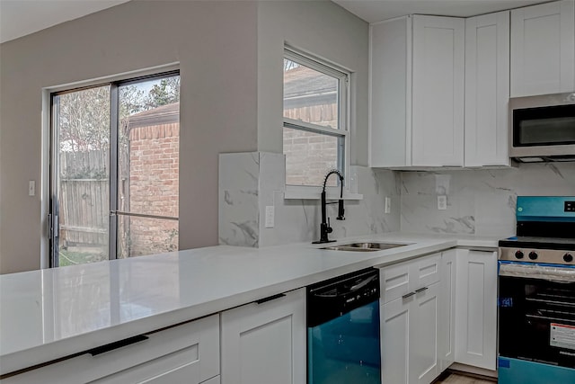 kitchen with sink, appliances with stainless steel finishes, white cabinets, and a wealth of natural light