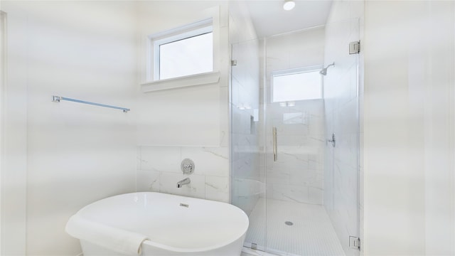 full bathroom featuring a stall shower and tile walls