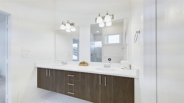 bathroom featuring marble finish floor, a sink, a shower stall, and double vanity