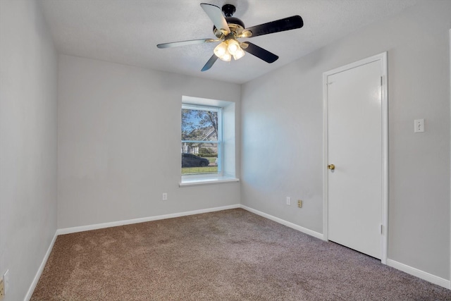 spare room with ceiling fan, carpet flooring, and baseboards