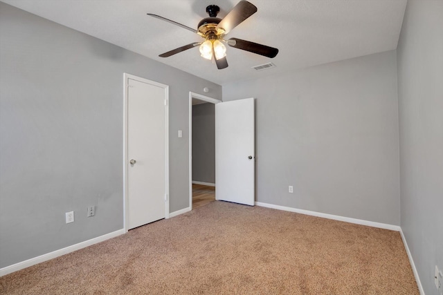 unfurnished bedroom featuring carpet floors, a ceiling fan, visible vents, and baseboards