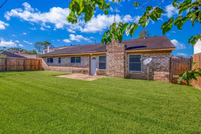 rear view of house featuring a yard, a chimney, a patio area, and a fenced backyard