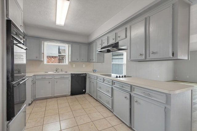 kitchen featuring black appliances, under cabinet range hood, light countertops, and gray cabinetry