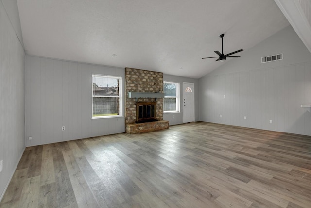 unfurnished living room featuring a ceiling fan, visible vents, a fireplace, and wood finished floors