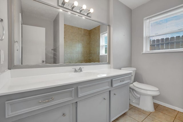 full bath featuring baseboards, tiled shower, toilet, tile patterned floors, and vanity