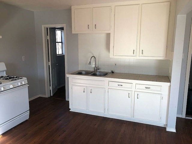 kitchen featuring white cabinets, decorative backsplash, dark hardwood / wood-style flooring, sink, and white gas range oven