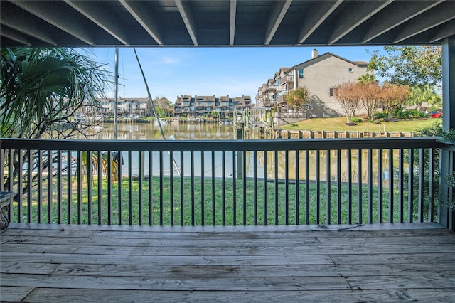 wooden terrace with a water view, a residential view, and a yard