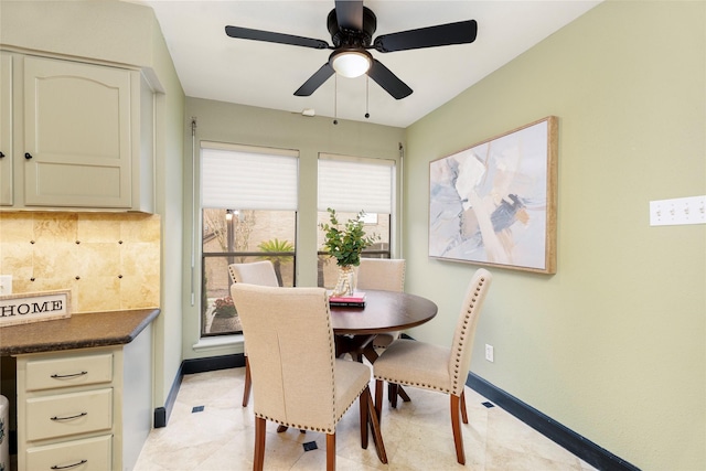 dining space featuring baseboards and a ceiling fan