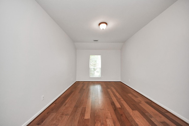 spare room with visible vents, baseboards, and wood finished floors