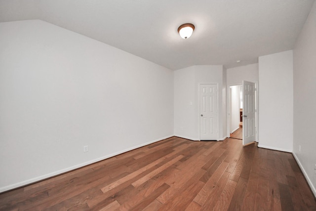 spare room with lofted ceiling, baseboards, and wood finished floors