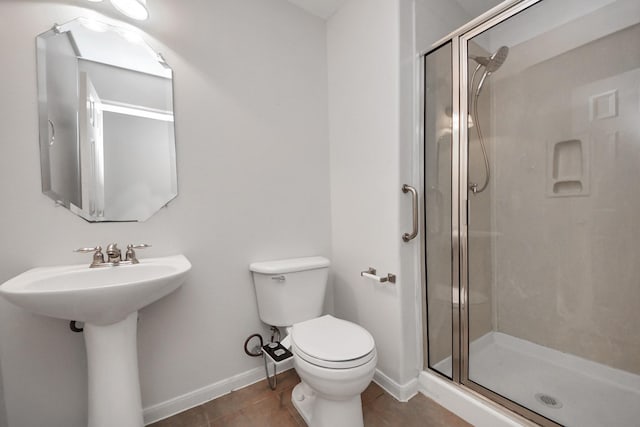 full bath featuring toilet, a stall shower, baseboards, and tile patterned floors