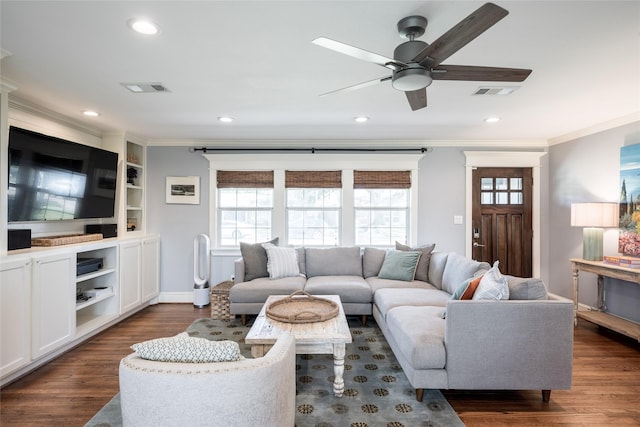 living room featuring dark hardwood / wood-style floors, a wealth of natural light, and ornamental molding