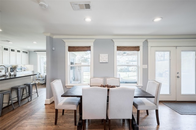 dining area featuring sink, dark wood-type flooring, crown molding, and french doors