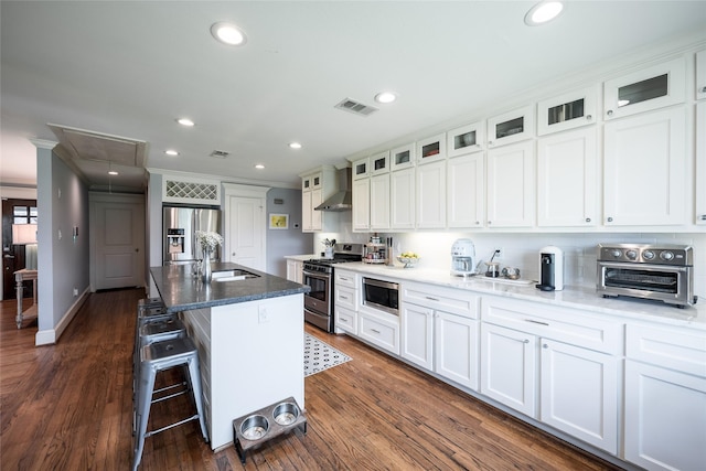 kitchen with white cabinets, an island with sink, and appliances with stainless steel finishes