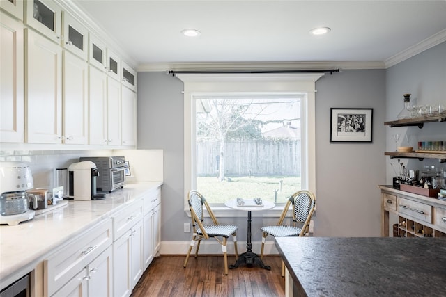 kitchen featuring white cabinets, dark wood-type flooring, ornamental molding, and decorative backsplash