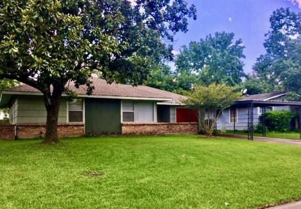 ranch-style home with brick siding and a front yard