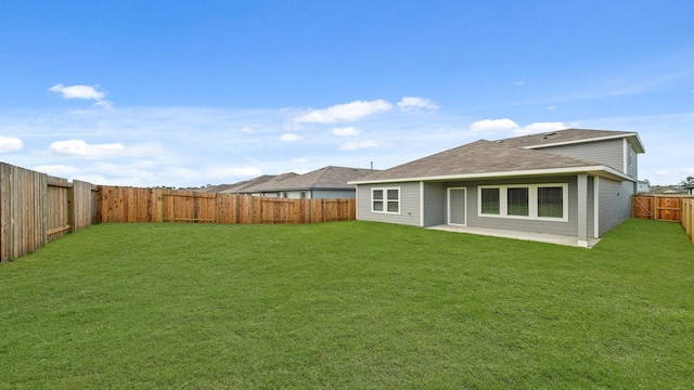 rear view of property featuring a patio area, a lawn, a fenced backyard, and roof with shingles