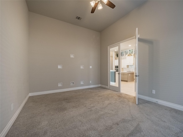 unfurnished room with visible vents, baseboards, light colored carpet, ceiling fan, and french doors