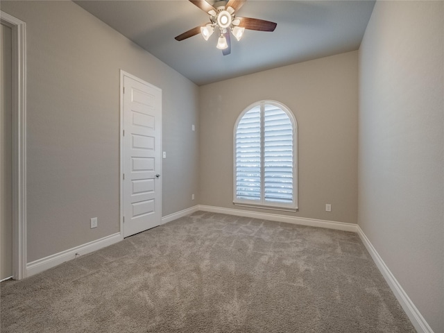 empty room with light carpet, ceiling fan, and baseboards